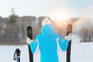 Woman Holds A Pair Of Skiing Looking For Ski Slope.