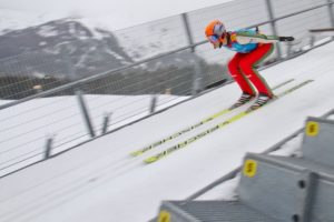 winter ski jumper flying down jump