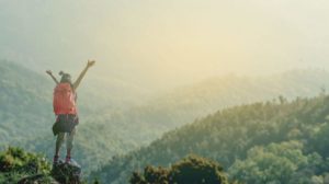 Hiker at summit arms outstretched 