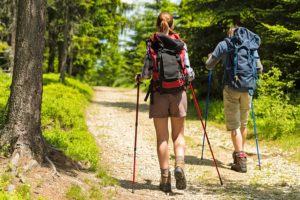 man and woman hikers on forest path