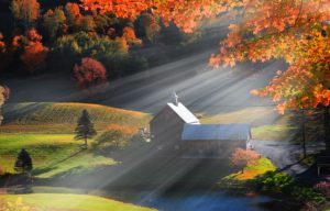 Old barn in Vermont rural side surrounded by fall foliage