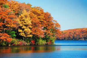 Great fall hiking with autumn colorful foliage over lake with beautiful woods