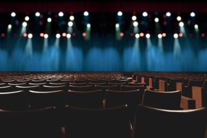 Rows of seats at Latchis Theater with lights on stage.