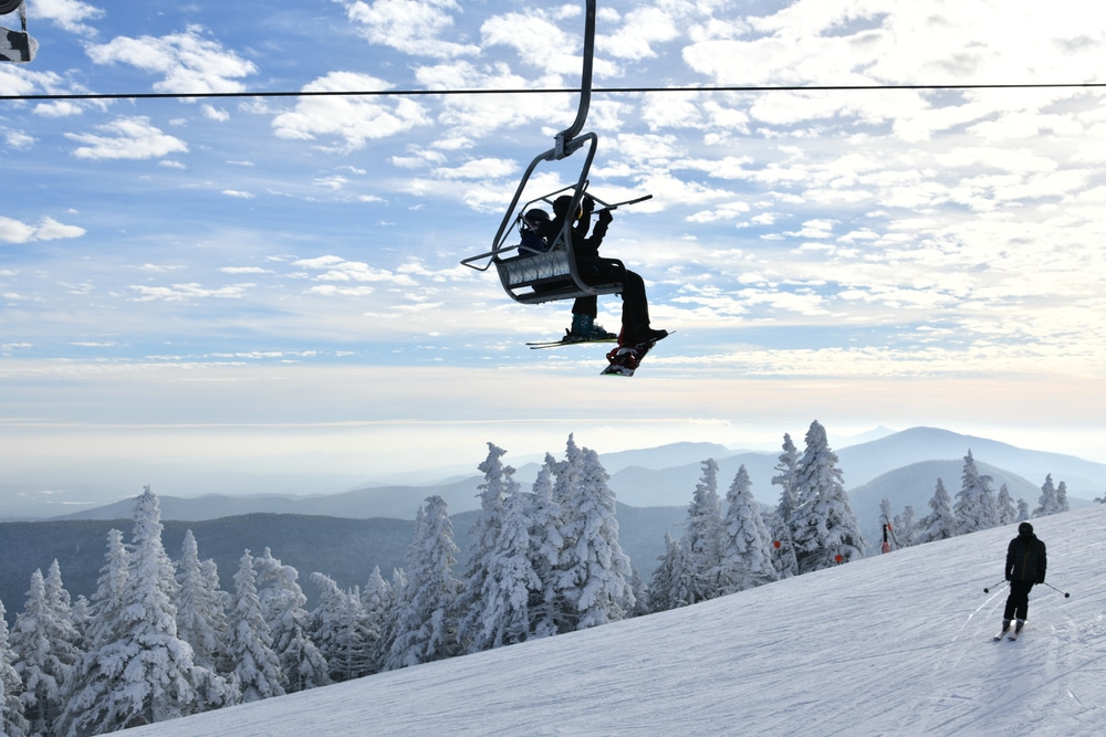 Skiers on a chairlift enjoying places like Mount Snow, Vermont and other best skiing in Vermont