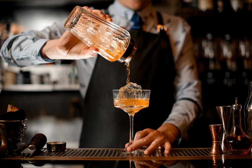 Barman pouring a cocktail at restaurants, like Peter Havens Restaurant in Brattleboro