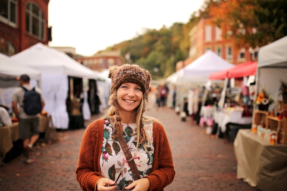 Woman standing in front of stalls at the Brattleboro Farmers Market