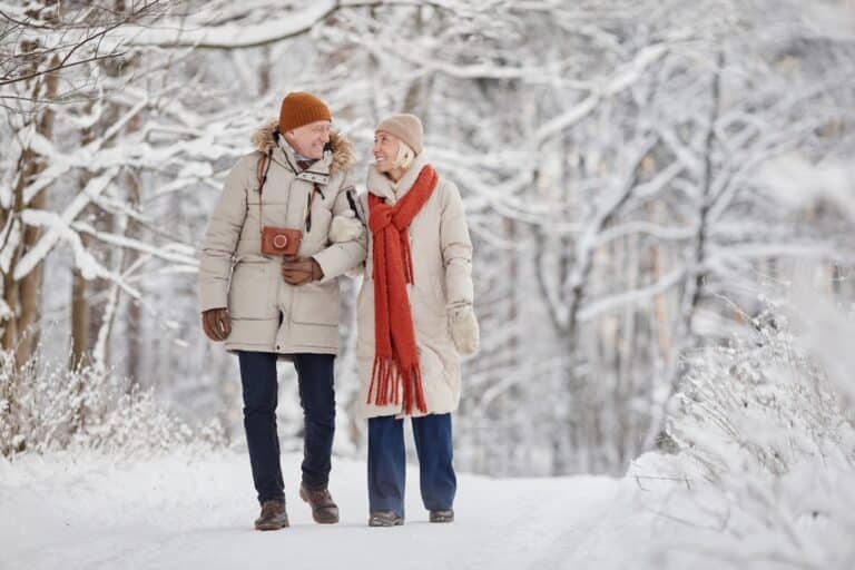 A couple enjoys a snowy walk at the Inn on Putney Road, one of the best places to stay in Brattleboro VT.