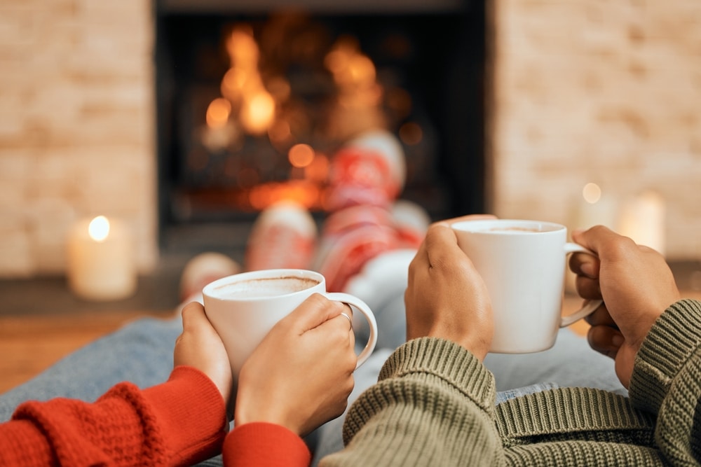 A couple enjoys a cozy cup of coffee near the fire at the Inn on Putney Road.