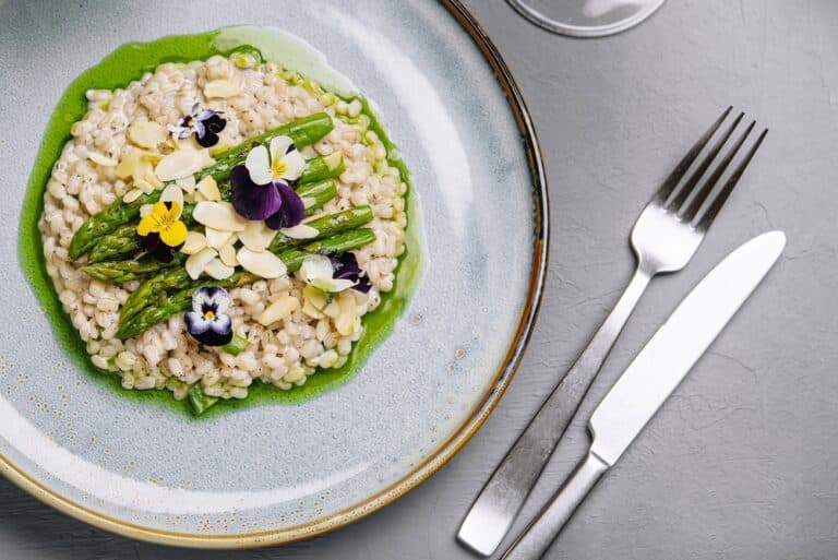 A plate of risotto adorned with edible flowers from one of the best Brattleboro VT restaurants for vegetarians.